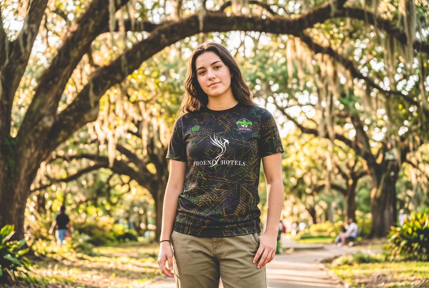 A supporter wearing the Jazz Fest retro shirt beneath live oaks